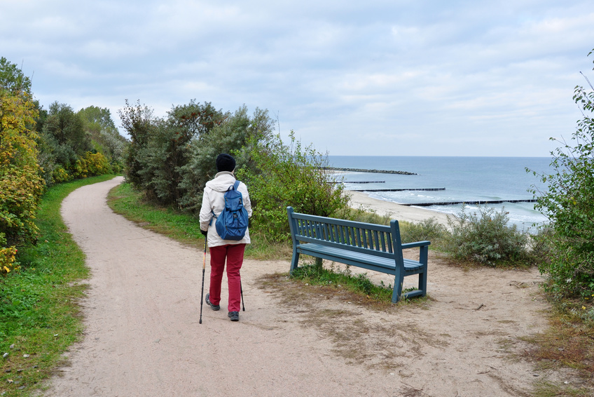 Frau betreibt Nordic Walking am Strand